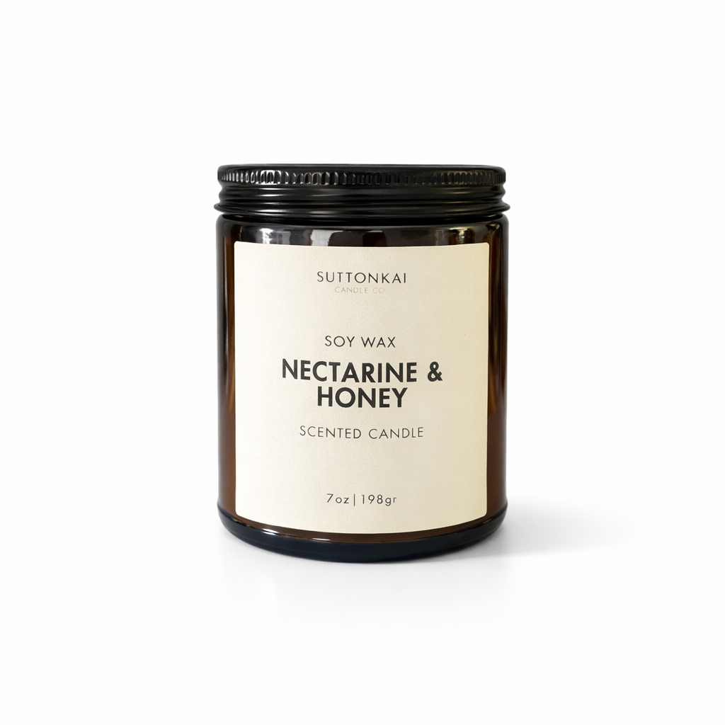 Suttonkai nectarine & honey scented candle with a black lid on a white background