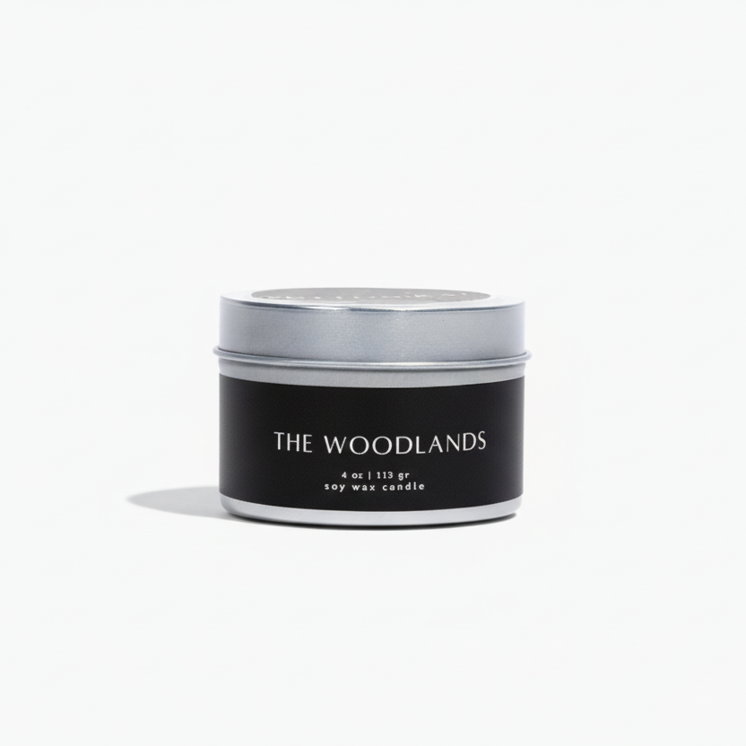 Candle jar with 'The Woodlands' branding on a white background